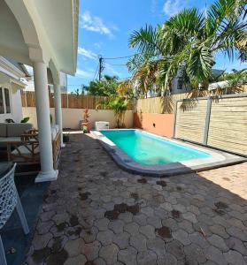 a swimming pool in a yard next to a house at Villa Ti CoCo Elegant Tropical Villa with Pool and Terraces in Trou aux Biches