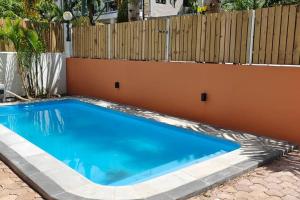 a blue swimming pool in front of a fence at Villa Ti CoCo Elegant Tropical Villa with Pool and Terraces in Trou aux Biches