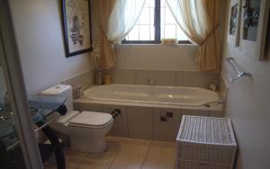 a bathroom with a toilet and a bath tub at Deck on Sea, 131 Nkwazi drive, Zinkwazi in Zinkwazi Beach +14 photos