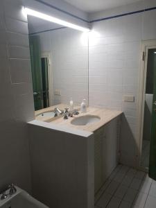 a bathroom with a sink and a large mirror at Domus Neroniana - Ingresso privato alla spiaggia. in Anzio