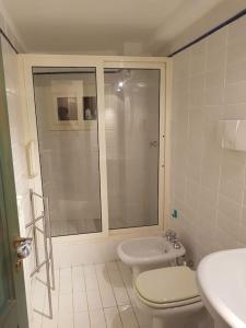 a bathroom with a shower and a toilet and a sink at Domus Neroniana - Ingresso privato alla spiaggia. in Anzio
