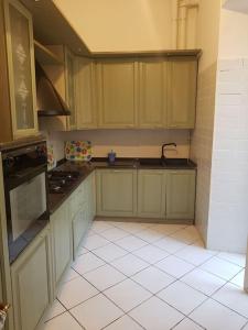 a kitchen with green cabinets and a white tile floor at Domus Neroniana - Ingresso privato alla spiaggia. in Anzio +7 photos
