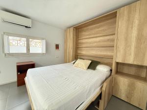 une chambre avec un grand lit avec une tête de lit en bois dans l'établissement Agi Peater Center, à Roses