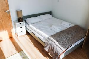 a small bed in a room with a night stand at Willa VITA Muszyna - rodzinne apartamenty blisko natury i atrakcji - 15min pieszo do centrum - 15min autem do stoku in Muszyna