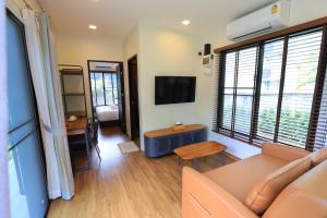 a living room with a couch and a tv at Willow Tree House Khao Yai in Mu Si