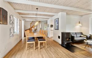 una sala da pranzo e un soggiorno con tavolo e camino di Gorgeous Home In Rømø With Sauna a Rømø Kirkeby