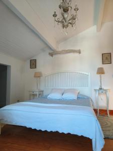 a bedroom with a bed with blue sheets and a chandelier at Coqueto Apartamento en Hendaya in Hendaye