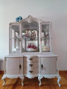 a white hutch with glass doors on a wooden floor at Coqueto Apartamento en Hendaya in Hendaye