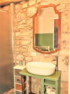 Un baño con lavabo y espejo en una pared de piedra. en Mirò - Escape with Romantic Lake View balcony, en Lezzeno