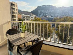 une table en bois sur un balcon avec une plante en pot dans l'établissement Agi Peater Center, à Roses