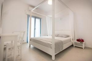 a white bedroom with a canopy bed and a window at Villa Sun in Skiros +46 photos