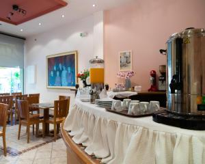 a table with plates and cups on it in a restaurant at Hotel Avra in Karditsa