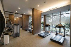a gym with a row of treadmills in a building at 2BR Luxury Condo with 10Ha garden di Marigold BSD in Lengkong-kulon