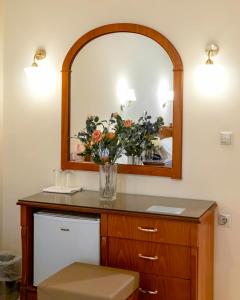 a bathroom with a mirror and a vase of flowers at Hotel Avra in Kardítsa +69 photos