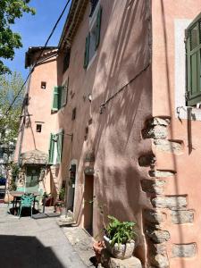 a building with a table and a chair next to it at Mon Abri in Garéoult