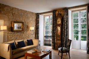 a living room with a couch and a clock at Hotel Pazo de Bieite in Boimorto