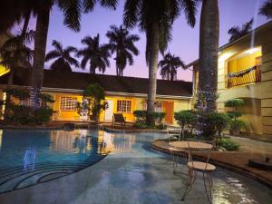 a resort with a swimming pool with tables and palm trees at At SILVER PALMS in Tzaneen