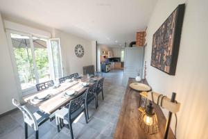 a dining room with a long table and chairs at La Villa du Pont Romain in Saint-Nectaire