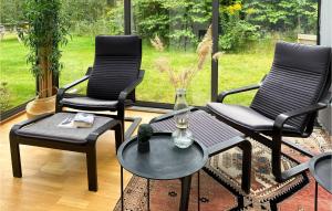 a patio with three chairs and a table and a window at Stunning Home In Grödinge With Kitchen in Näs