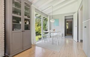 Una cocina y un comedor con mesa y sillas. en Two-Bedroom Holiday Home In Tisvildeleje, en Tisvildeleje