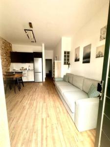 ein Wohnzimmer mit einer weißen Couch und einer Küche in der Unterkunft Apartamento Rincón del Mar in La Santa