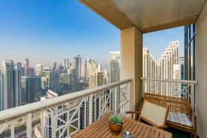 a balcony with a table and a view of a city at Luxury High Floor 1BR with Full Burj Khalifa View by Auberge in Dubai