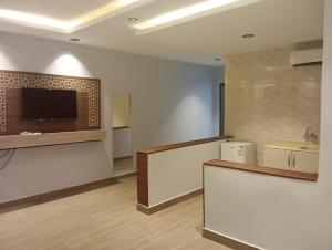 a large room with a counter and a tv on the wall at فندق ملاذ Malath Hotel in Ad Darb