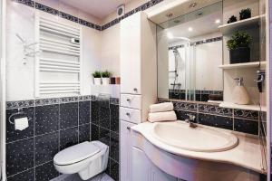 un bagno con lavandino, WC e specchio di Apartament Widokowy Górski Taras a Kościelisko Altre 15 foto