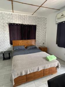 a bedroom with a large bed with a wooden headboard at Omanye Lodge in Accra +6 photos