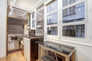 a kitchen with a sink and some windows at Paris Marais Tiny MERRISAS in Paris