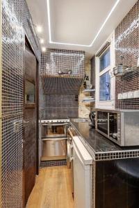 a kitchen with a sink and a microwave at Paris Marais Tiny MERRISAS in Paris