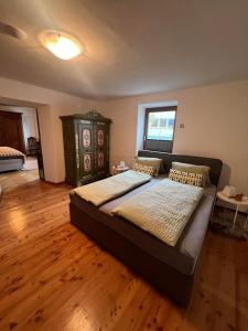 a large bed in a room with a wooden floor at Ferienwohnung Steinlicht in Lienz