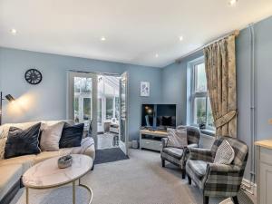a living room with a couch and chairs and a tv at Bagshaw Mews in Bakewell