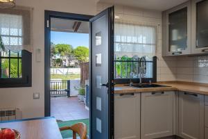 a kitchen with a door leading to a patio at AT153 First line of the beach in Creixell