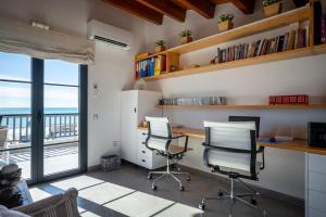 an office with two chairs and a desk and a window at AT153 First line of the beach in Creixell