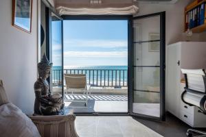 a room with a glass door with a view of the ocean at AT153 First line of the beach in Creixell