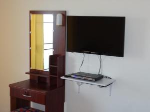 a tv on a wall with a laptop on a shelf at Rayong Condochain in Ban Phe