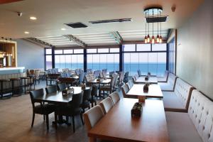 a restaurant with tables and chairs and a view of the ocean at Pasaport Pier Hotel in İzmir