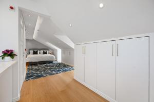 Habitación blanca con cama y armario grande. en Nightingale Suites, en Londres