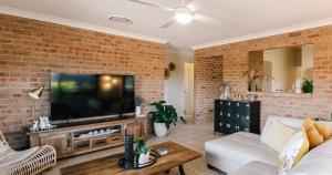 a living room with a brick wall at Budgaribah in Old Bar