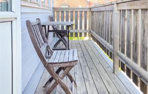 a wooden chair sitting next to a table on a porch at 2 Bedroom Amazing Apartment In Visby in Visby