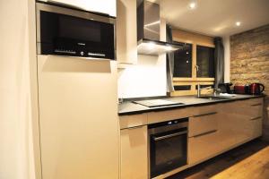 a kitchen with a microwave and a stove top oven at Comfort apartment in Zermatt