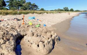a sand castle on a beach next to the water at 1 Bedroom Nice Home In Ystad in Ystad +9 photos