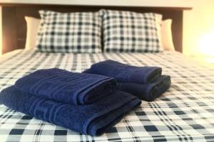 カレタ・デ・ファマラにあるfamara surf wifiのベッドの上に座るタオル3枚