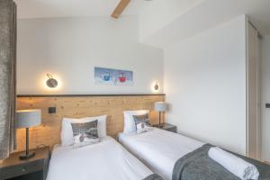 zwei nebeneinander stehende Betten in einem Schlafzimmer in der Unterkunft Alpe d'Huez Houses - Chez Emma - Fermes de l'Alpe - du cachet dans le vieil Alpe in L'Alpe-d'Huez