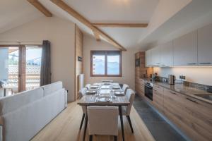 ein Esszimmer mit Tisch und eine Küche in der Unterkunft Alpe d'Huez Houses - Chez Emma - Fermes de l'Alpe - du cachet dans le vieil Alpe in L'Alpe-d'Huez