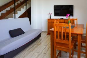 Una sala de estar con una mesa de comedor y un sofá. en House Loma Gomera in San Sebastian, en San Sebastián de la Gomera