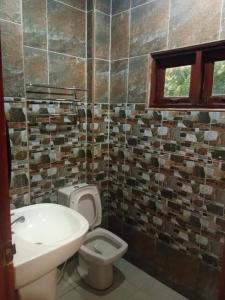 a bathroom with a sink and a toilet and a window at Mgrand Hotel in Ban Non Sombun