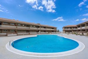 a large swimming pool in front of a building at Seaside Apartment with Spacious Terrace, Pool, and Wi-Fi in Santa Cruz de Tenerife