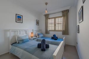 a bedroom with two beds and a window at Seaside Apartment with Spacious Terrace, Pool, and Wi-Fi in Santa Cruz de Tenerife +19 photos